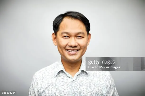 Portrait of mid adult male professional smiling. Confident businessman is wearing shirt. Executive is over white background.