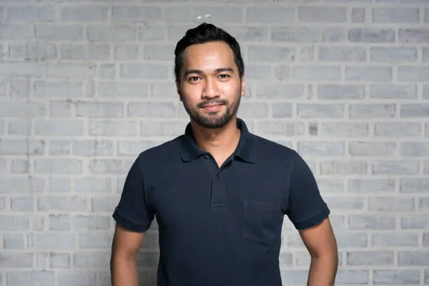 Portrait of a Malaysian man smiling and looking at camera.